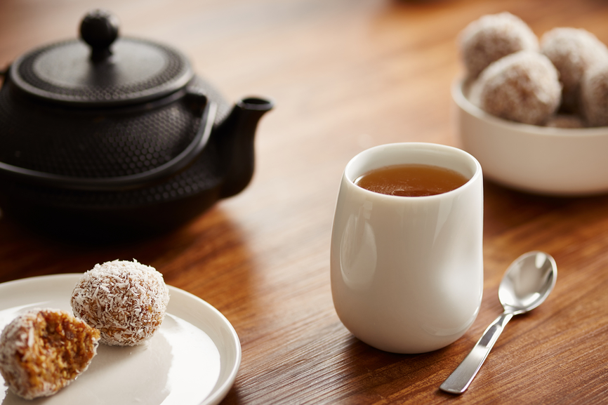 Tea cup with paleo cocoa, nuts, lime and dates balls