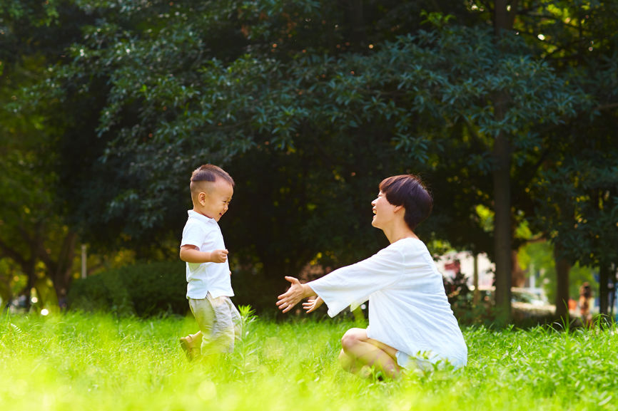 Happy Little Asian Boy With Her Mother Outdoor In The Summer Park