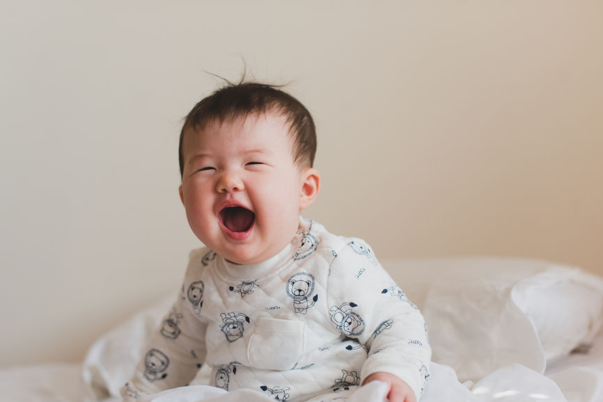 Happy Baby Sitting Up And Laughing